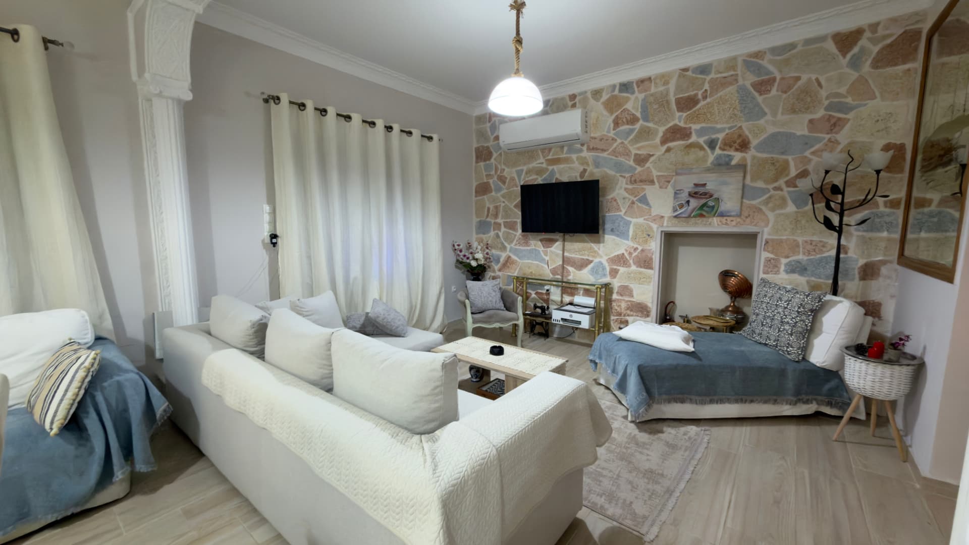 Σαλόνι με καναπέδες και πέτρινο τοίχο